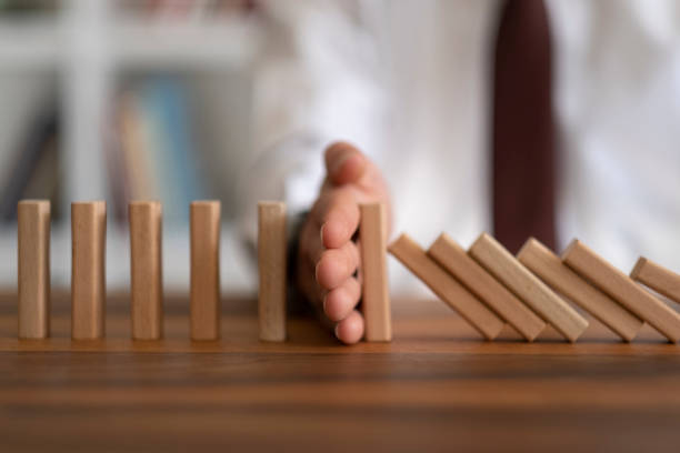 istock Businessman Stop Domino Effect. Risk Management and Insurance Concept 1421668849
