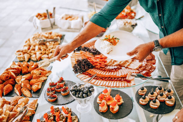 istock Man holding plate and taking food from buffet table during breakfast in hotel 1421672089