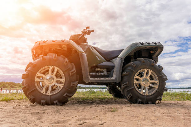 istock ATV on the sandy shore of the lake. side view. 1421673018