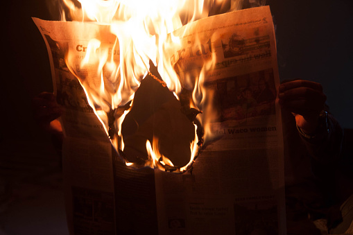A newspaper burning the shape of a heart