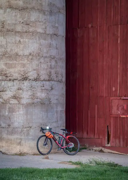 lightweight gravel bike with a carbon frame against silo of old, weathered barn at Colorado foothills