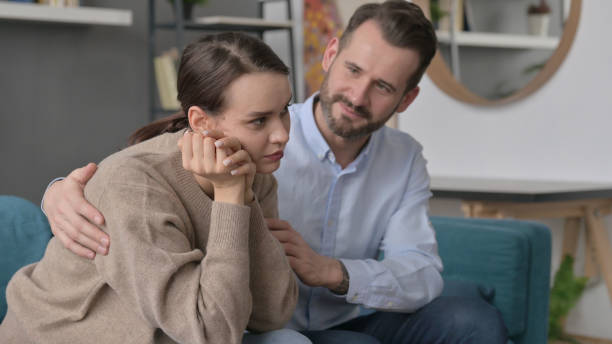 istock Man Trying to Comfort Upset Female Partner on Sofa 1421687907