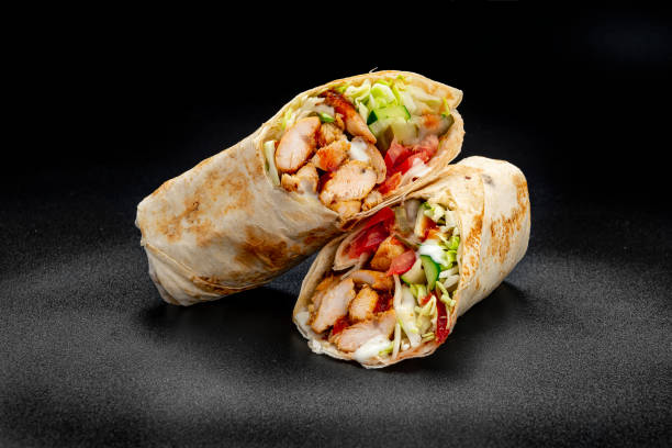 Beef shawarma on a dark background. Shawarma with beef in pita bread Beef shawarma on a dark background. Shawarma with beef in pita bread. Photo for the menu shawarma stock pictures, royalty-free photos & images