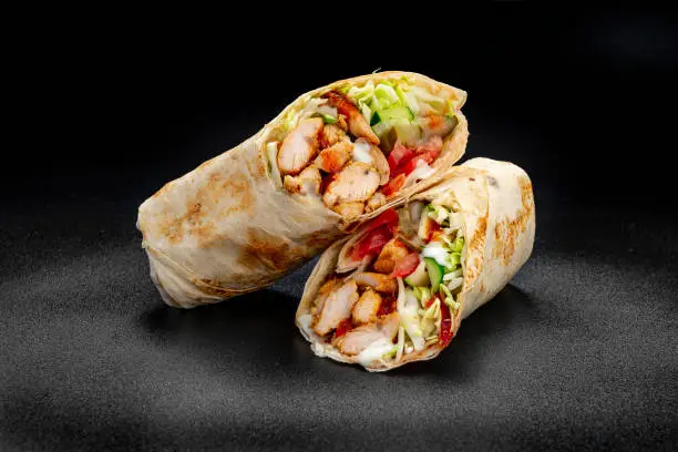 Beef shawarma on a dark background. Shawarma with beef in pita bread. Photo for the menu