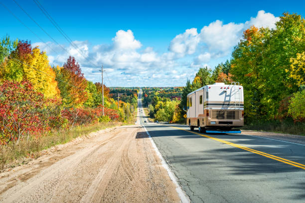 RV drives on highway leading through autumn landscape near Barrie, Ontario, Canada.