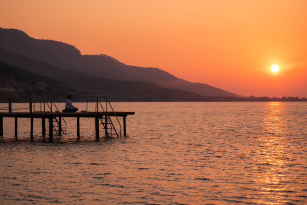 istock Woman practicing yoga alone on a pier at sunrise 1421693592