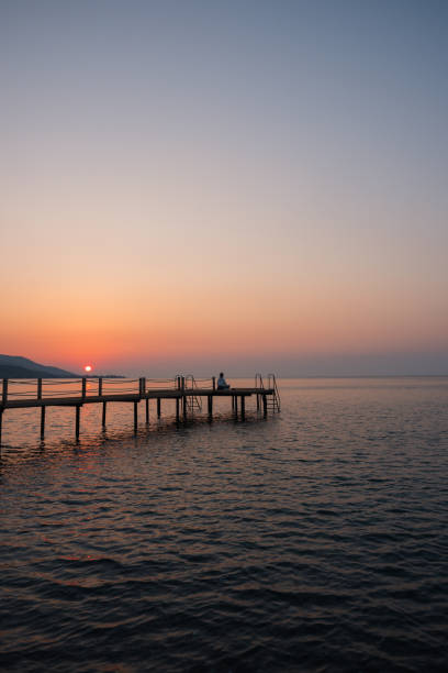 istock Woman practicing yoga alone on a pier at sunrise 1421693926