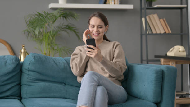 istock Woman having Success on Smartphone at home 1421697131