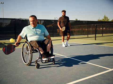 Men in wheelchair playing tennis and conquer adversity