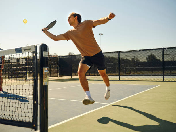 młodzi dorośli grający w pickleball na publicznym boisku - mixed doubles zdjęcia i obrazy z banku zdjęć