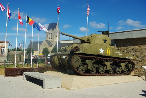 Sherman tank at airbone museum at  village Sainte-Mère-Église with church in the background, Normandy