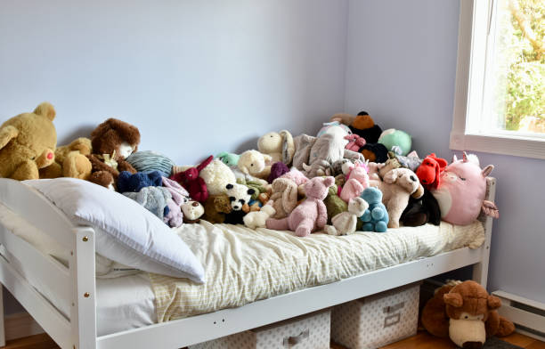 dormitorio del niño con juguetes de peluche abarrotando la cama - makeover series fotografías e imágenes de stock