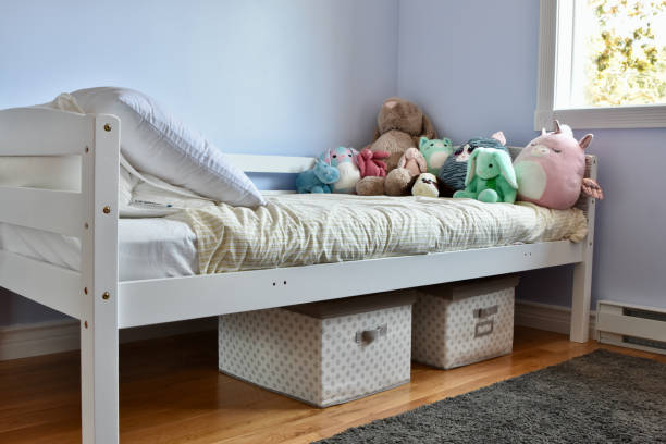 Simple and modern child's room with plush toys, bed and storage for toys Easy storage baskets for kid's toys under bed, with traditional bunk bed twin bed stock pictures, royalty-free photos & images