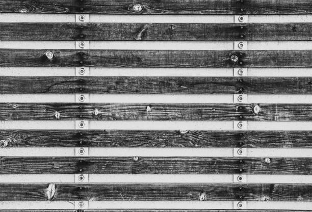 Black and white industrial rustic style background with wood slabs attached to strips of metal with bolts