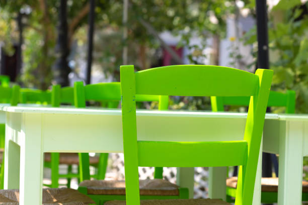 Photo showing marble topped restaurant tables and wooden chairs ready for al fresco dining. The buxus topiary balls pictured near the tables are in fact artifical for low maintenance.