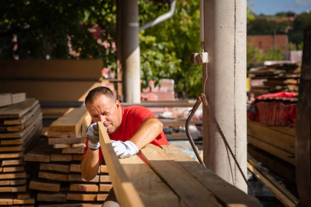 istock One man choose wood plank at warehouse or construction site 1421720150