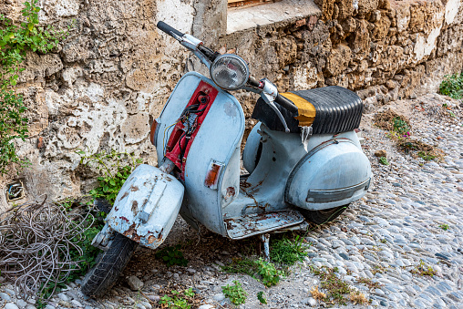 Abandoned disused scrap scooter in the old town of Rhodes island, Greece.