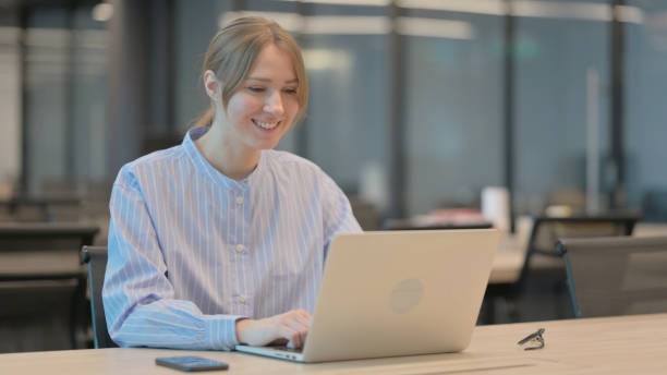 istock Young Woman Talking on Video Call on Laptop in Office 1421724634