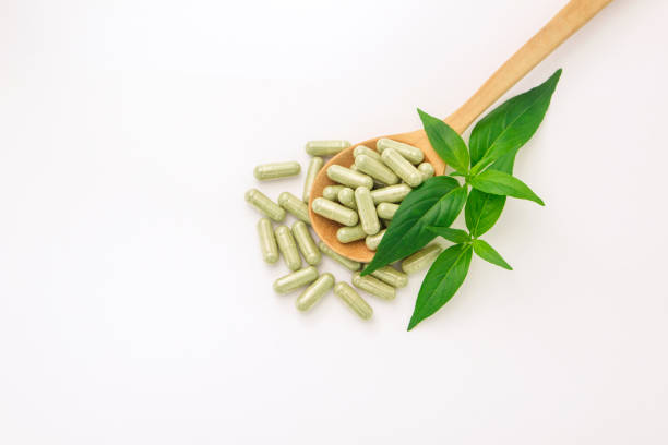 istock Andrographis paniculata capsule in wooden spoon and tip andrographis paniculata plant on white paper background. 1421737646