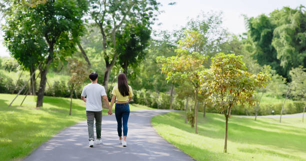 istock asian couple walking in park 1421742655