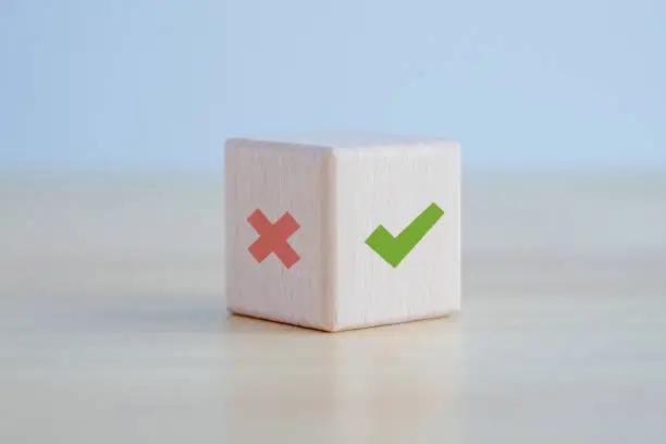 Photo of Green correct check mark and red wrong or cross icon on wooden block for true or false changing mindset or way of adapting to change leader and transform quiz answer and poll concept.