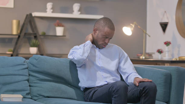 istock African Man having Neck Pain while Sitting on Sofa 1421759587