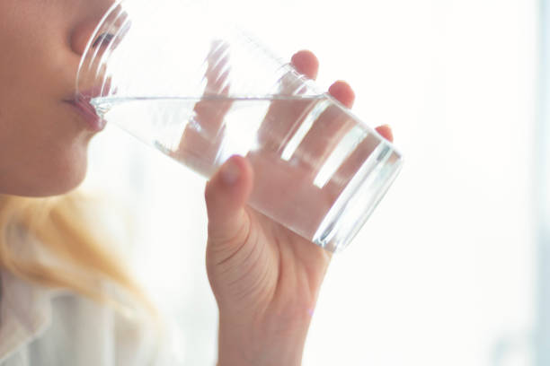 istock Woman drinking clean pure water from a glass. 1421764206