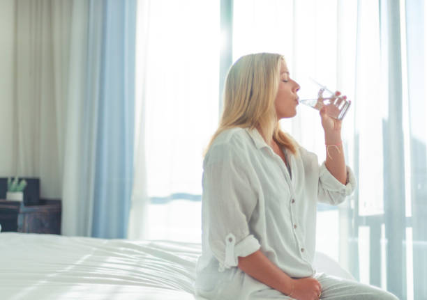 istock Woman drinking clean pure water from a glass 1421764551