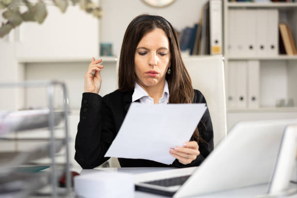 istock Sad woman bookkeeper doing paperwork in office 1421764970