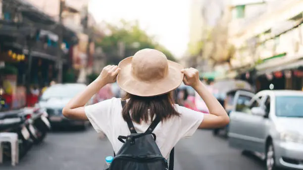 Photo of Rear view of asian traveller woman with backpack and hat staycation travelling at outdoor on day.