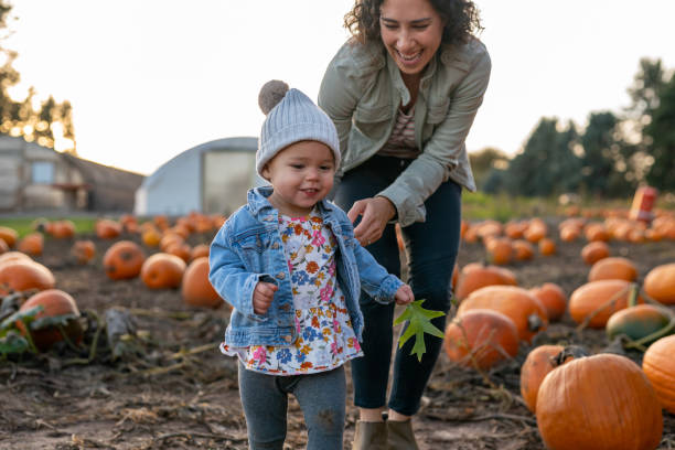 istock Ethnic thirty year old mom playing with her toddler at a pumpkin patch 1421771677