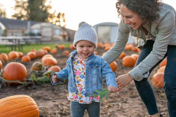 istock Ethnic thirty year old mom playing with her toddler at a pumpkin patch 1421771690