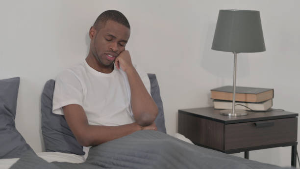 istock African Woman Taking Nap while Sitting in Bed 1421772426