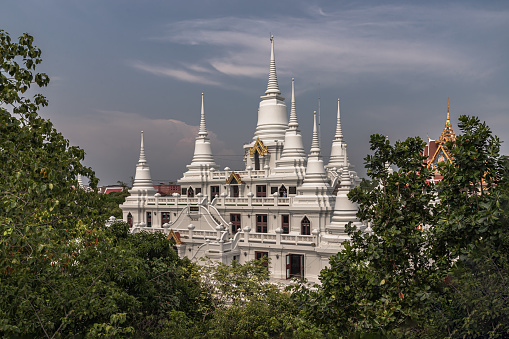 Bangkok, Thailand - 01 May 2022 : Large elaborate white Buddhist Pagoda with multiple spires at Wat Asokaram Temple. Space for text, Selective Focus.