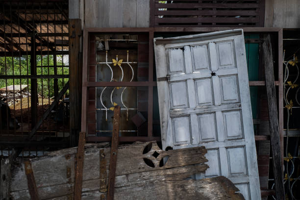 istock Old frames and shutters from dismantled are stacked against each other front of front old house waiting to be sold at auction. 1421774651