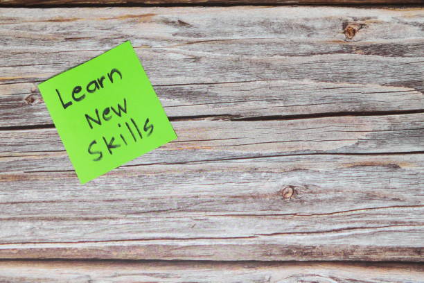 istock Learn new skills for self improvement and personal development concept. Green sticky note reminder in wooden background with copy space. 1421777739