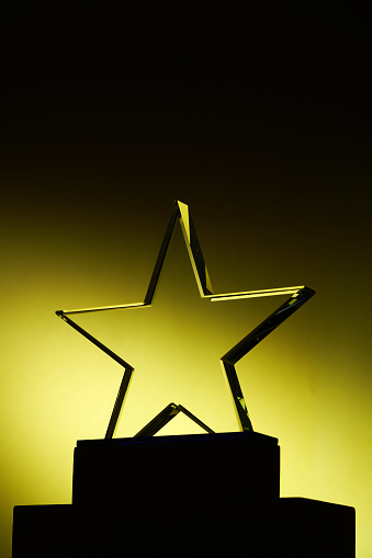 crystal trophy with star shape design against yellow background