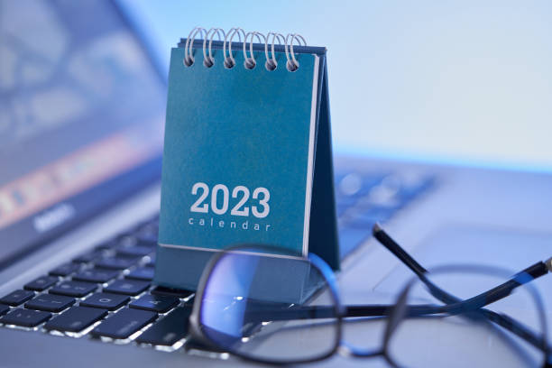 2023 dsk calendar on laptop  with eyeglasses - note pad desk office meeting imagens e fotografias de stock