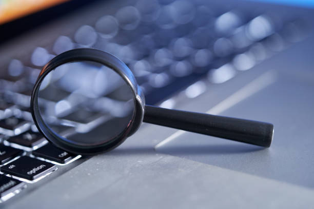 Magnifying glass on laptop for various search concepts, internet, medicine, research, crime, plus copy space in the magnifying glass, Studio shot, processed in raw mode for best quality