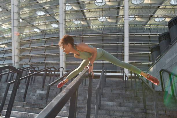 istock Young black sports woman doing exercise on railing 1421791230