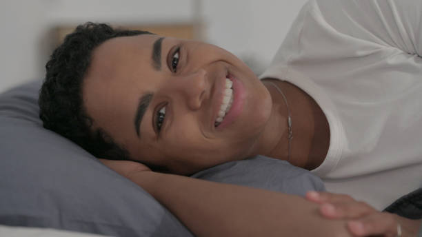 istock African Woman Talking on Video Call while Laying in Bed 1421791625