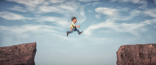 istock A man jumps from one rock to another. 1421791683