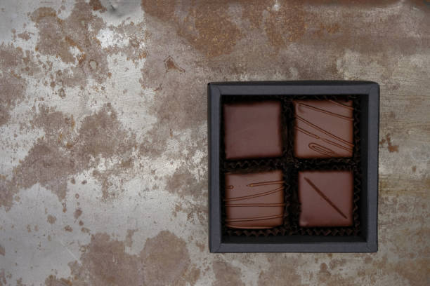 small chocolate gift set in a square black box on a rusty metal surface. - craft chocolate candy black box imagens e fotografias de stock