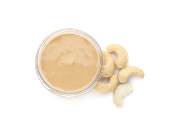 istock Jar with delicious cashew butter and nuts on white background, top view 1421798100