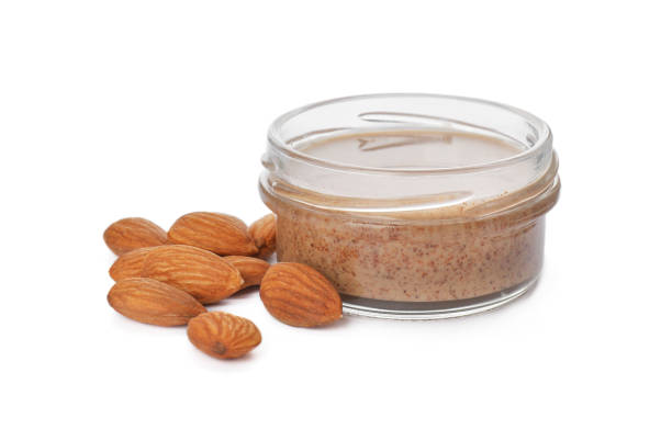 istock Jar with delicious nut butter and almonds on white background 1421798116