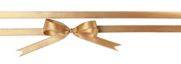 istock Beautiful golden ribbons with bow on white background, top view 1421798351
