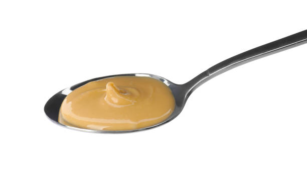 istock Spoon of delicious peanut butter on white background 1421798517