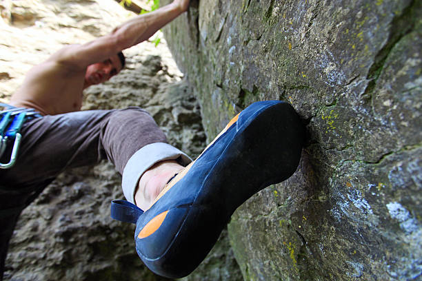 istock Rock climber about to start climbing his route 142180103