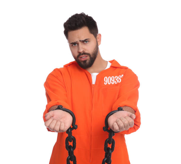 istock Prisoner in jumpsuit with chained hands on white background 1421801544