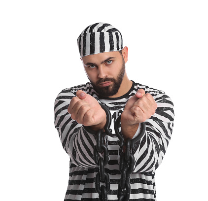 Prisoner in special uniform with chained hands on white background